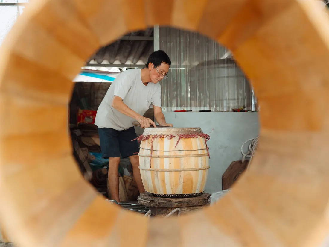 Casco de tambor de duelas de madera en primer plano, con un taller de montaje al fondo